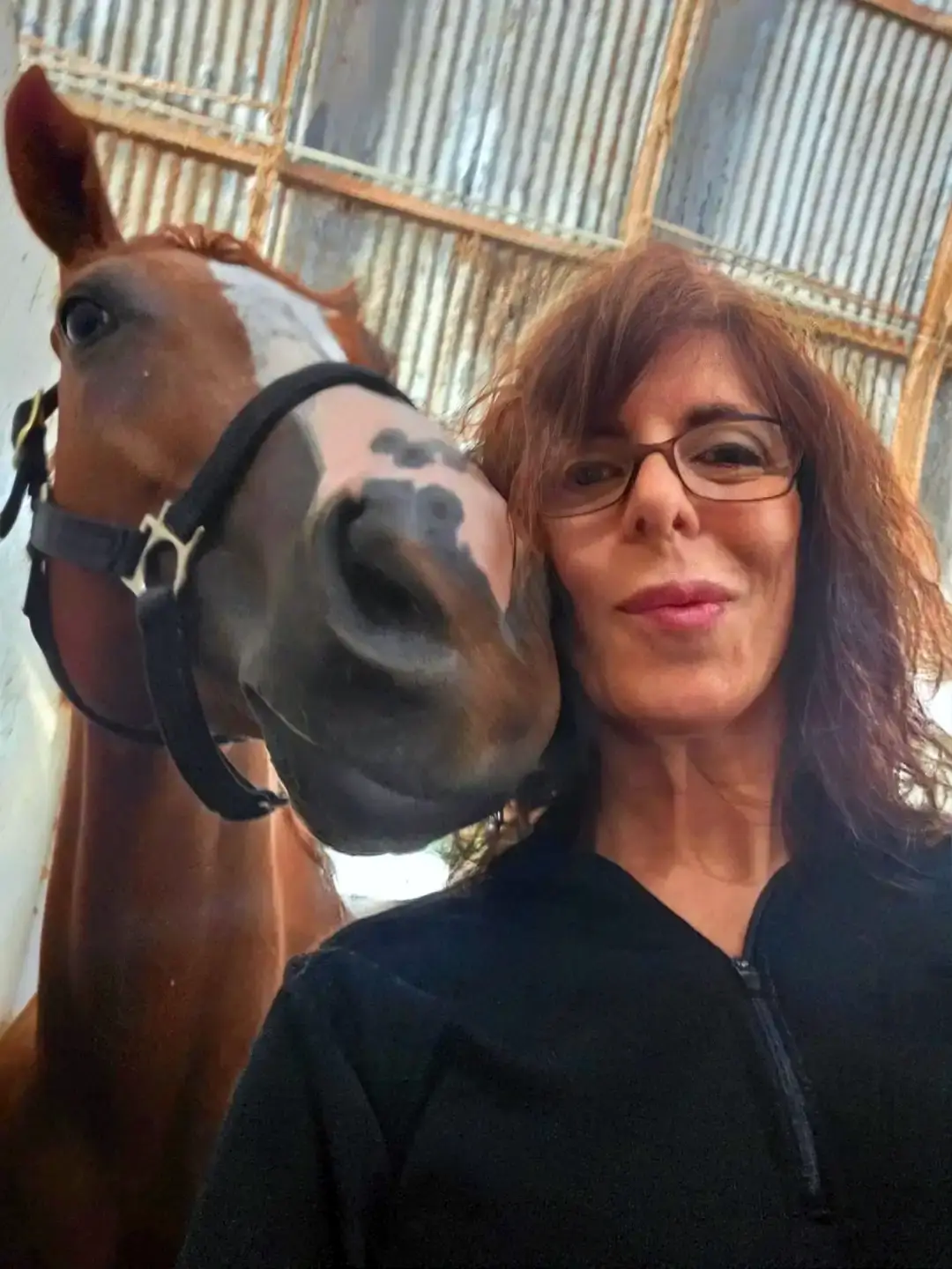 Shana Williams being kissed by one of her horses
